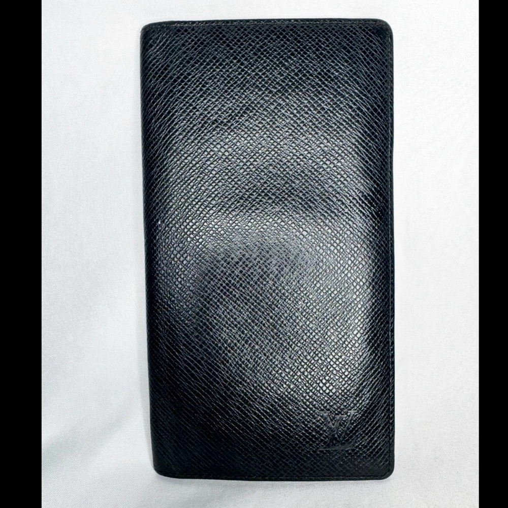 Louis Vuitton Brazza Wallet crafted from black Taiga leather. Code MI0090